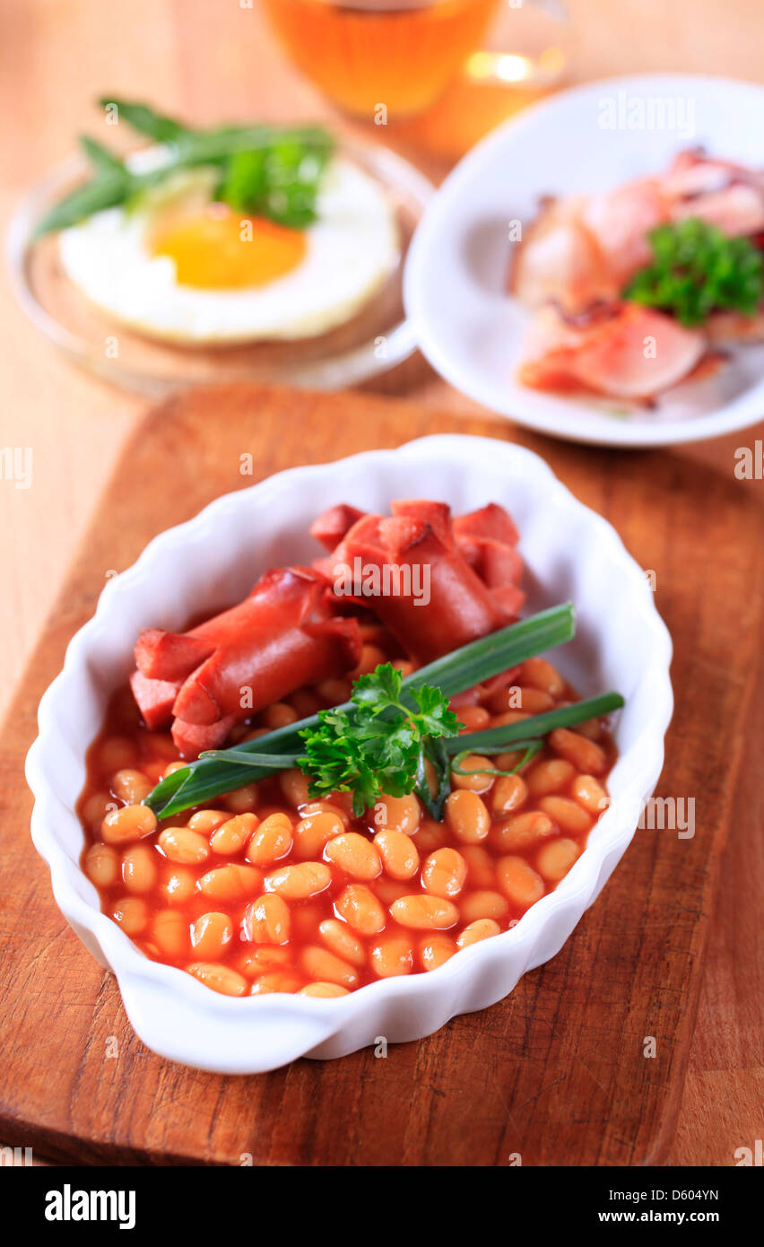 English breakfast of baked beans, sausages, fried egg and bacon Stock Photo