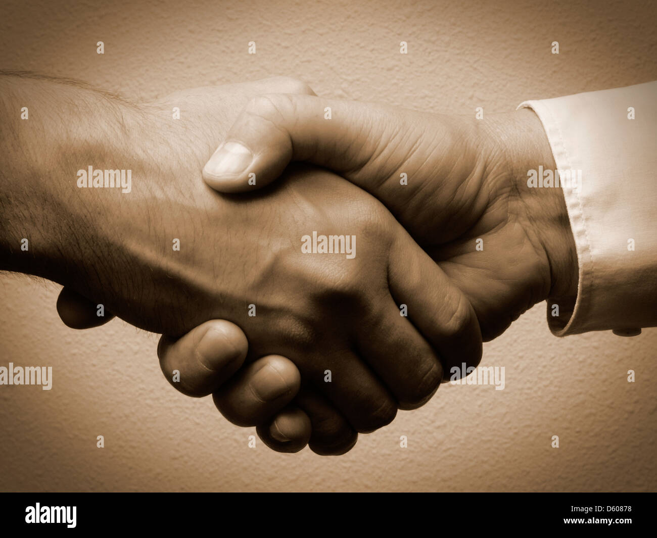 Handshake with two male hands one white cuff one without with lith-print effect Stock Photo