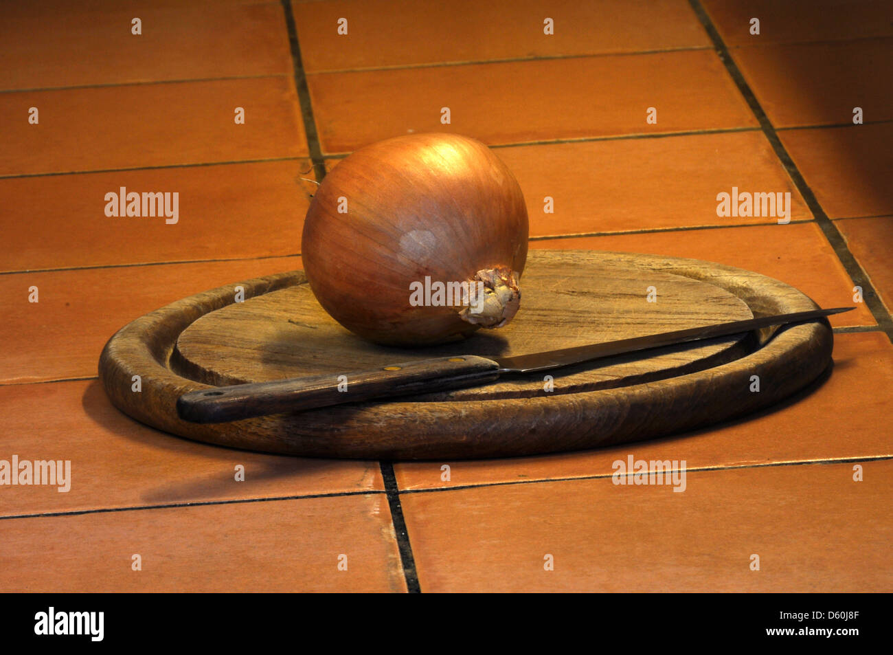 One unpeeled onion on a wooden chopping board Stock Photo - Alamy