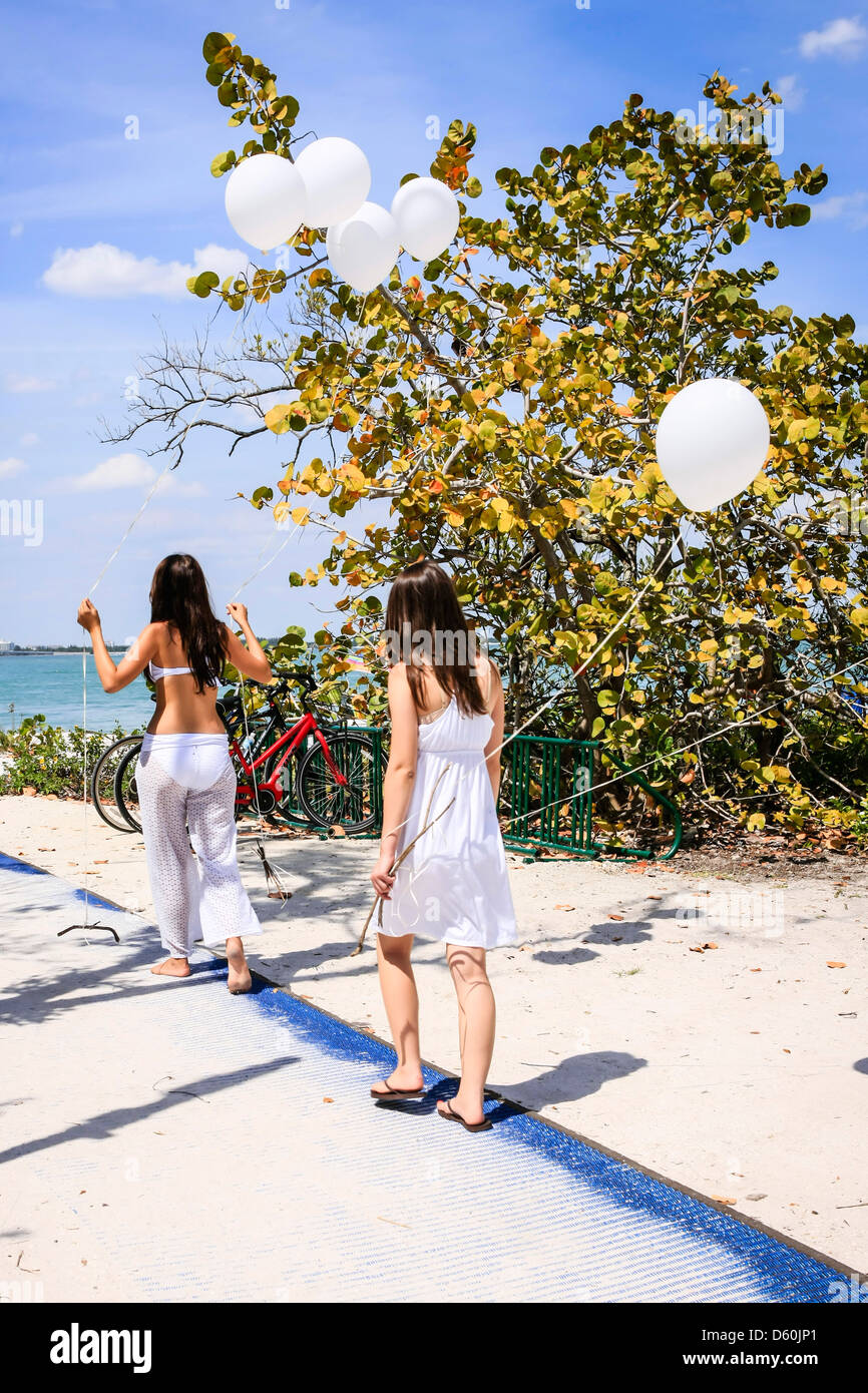 Two Teenage Girls Carrying Balloons To The Beach At Sanibel Florida Stock Photo Alamy