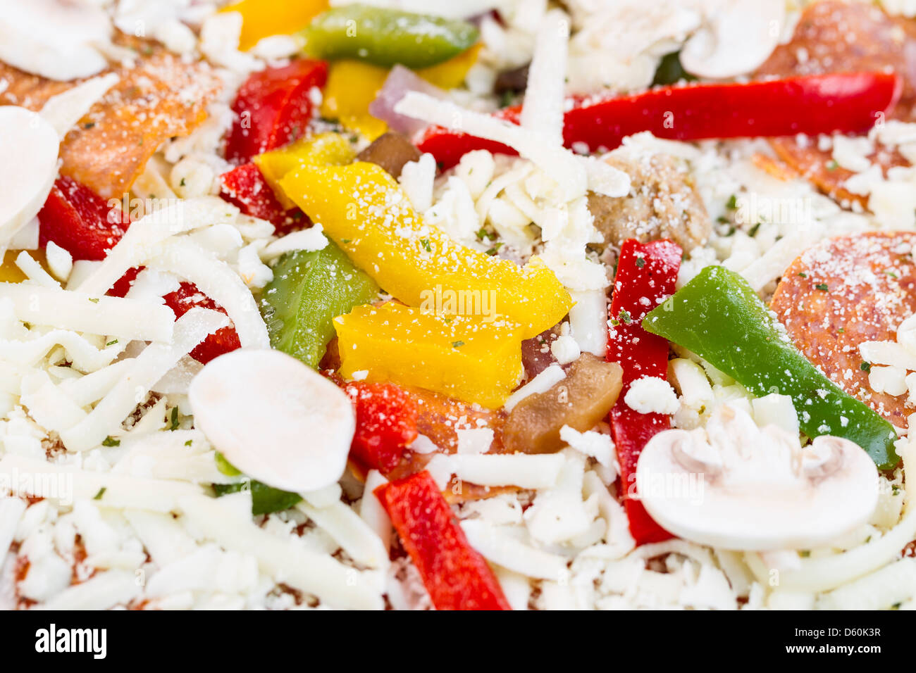 Horizontal macro photo closeup of raw pizza with focus on yellow and green peppers Stock Photo