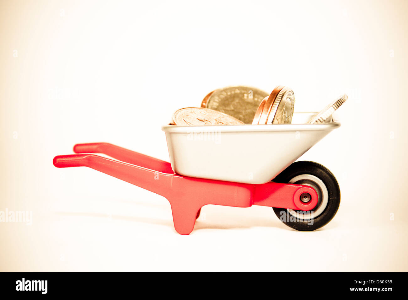 Coins in small plastic toy wheelbarrow Stock Photo Alamy