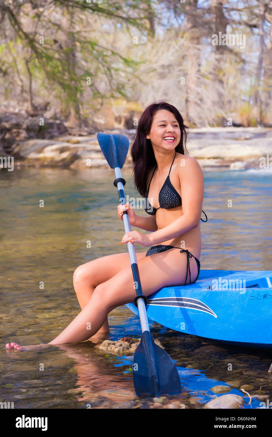 Young woman in bikini sitting on kayak paddle boat Stock Photo