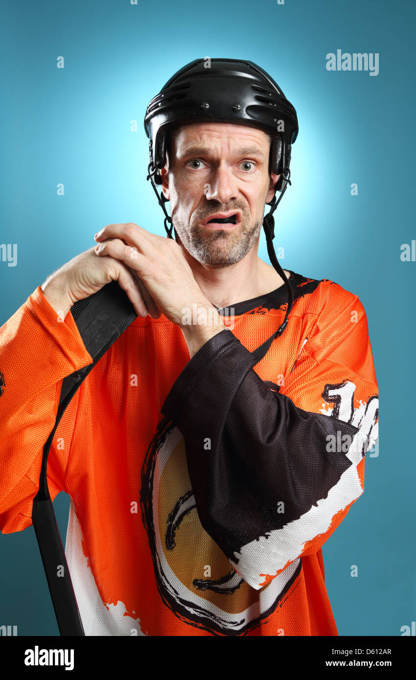 Humourous shot of a hockey player leaning on his hockey stick making a