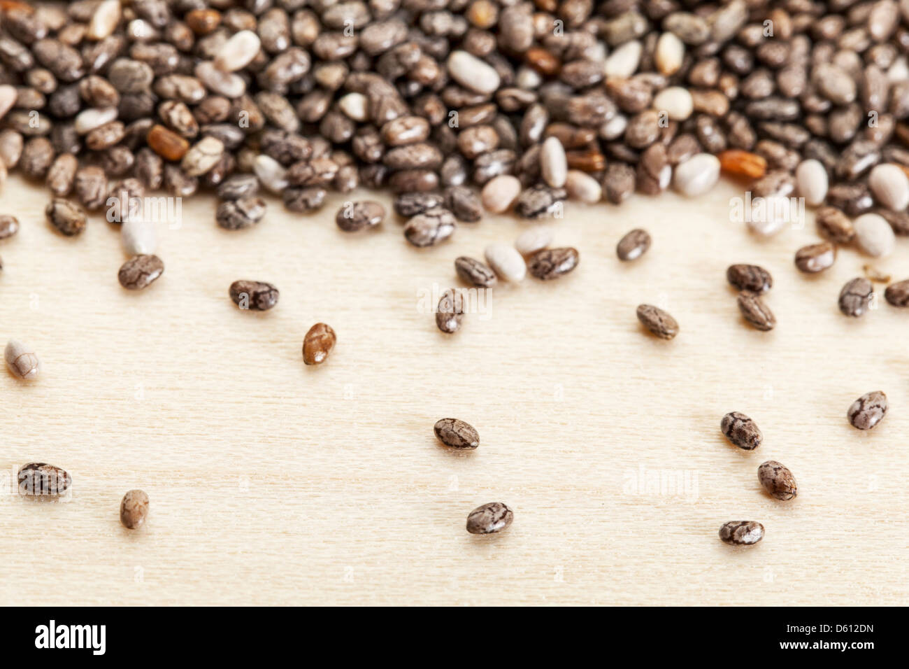 chia seeds on poplar wood surface - a close-up with a shallow depth of field Stock Photo