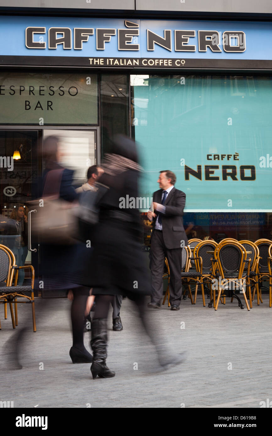 Pedestrians passing a Caffe Nero Coffee shop at the junction between Tooley Street and More London Place, Southwark, London. Stock Photo