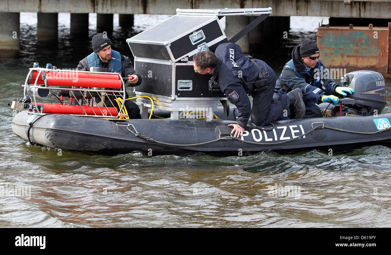Thuringian police officers and a diving robot sit in a boat prior to an operation on the Cospudener Lake in Markkleeberg-Leipzig, Germany, 10 April 2012. The police officers used the robot to continue their search for the missing 42 year old who disappeard after a dive. Photo: Jan Woitas Stock Photo