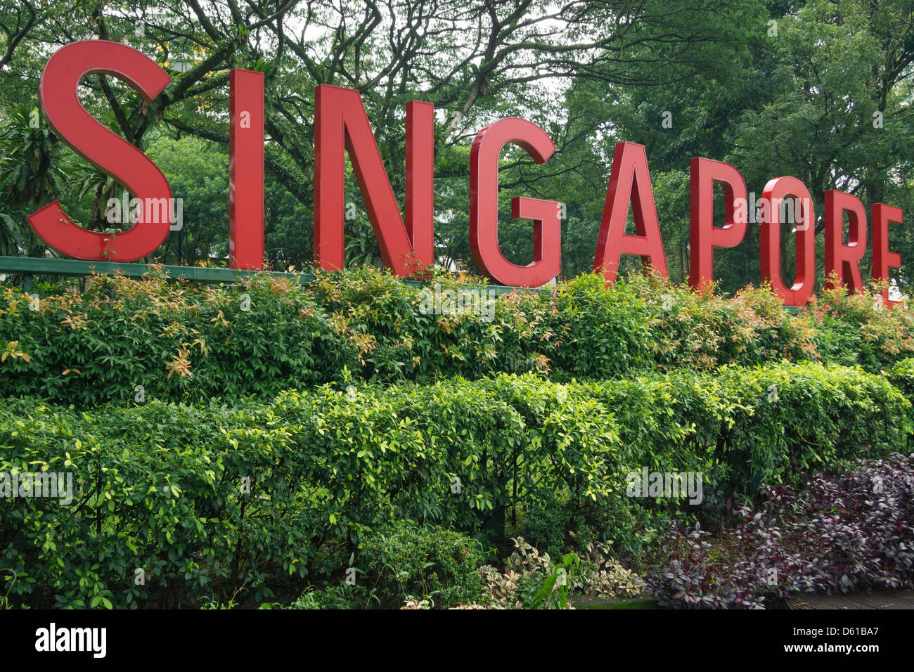 big red letters Singapore stay in green fresh bushes with park trees