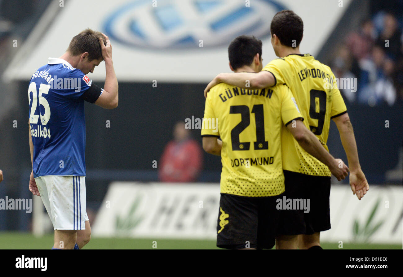 Schalke's Klaas Jan Huntelaar (L-R) looks disappointed while Dortmund's Ilkay Guendogan and Robert Lewandowski walk past him during the Bundesliga soccer match between FC Schalke 04 and Borussia Dortmund at the Veltins Arena in Gelsenkirchen, Germany, 14 April 2012. Photo: BERND THISSEN   (ATTENTION: EMBARGO CONDITIONS! The DFL permits the further  utilisation of the pictures in IP Stock Photo