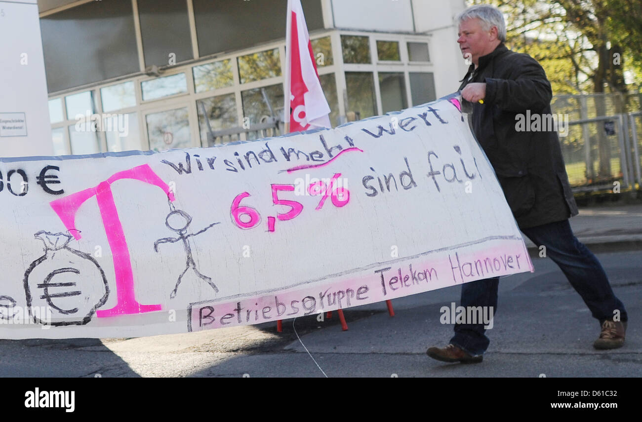 A Telekom employee stands next to a warning strike banner at the Telekom site in Hanover, Germany, 16 April 2012. The German service sector union Verdi called for a strike of the Telekom staff members demanding a 6.5 percent pay rise for the 85,000 employees. Photo: JULIAN STRATENSCHULTE Stock Photo
