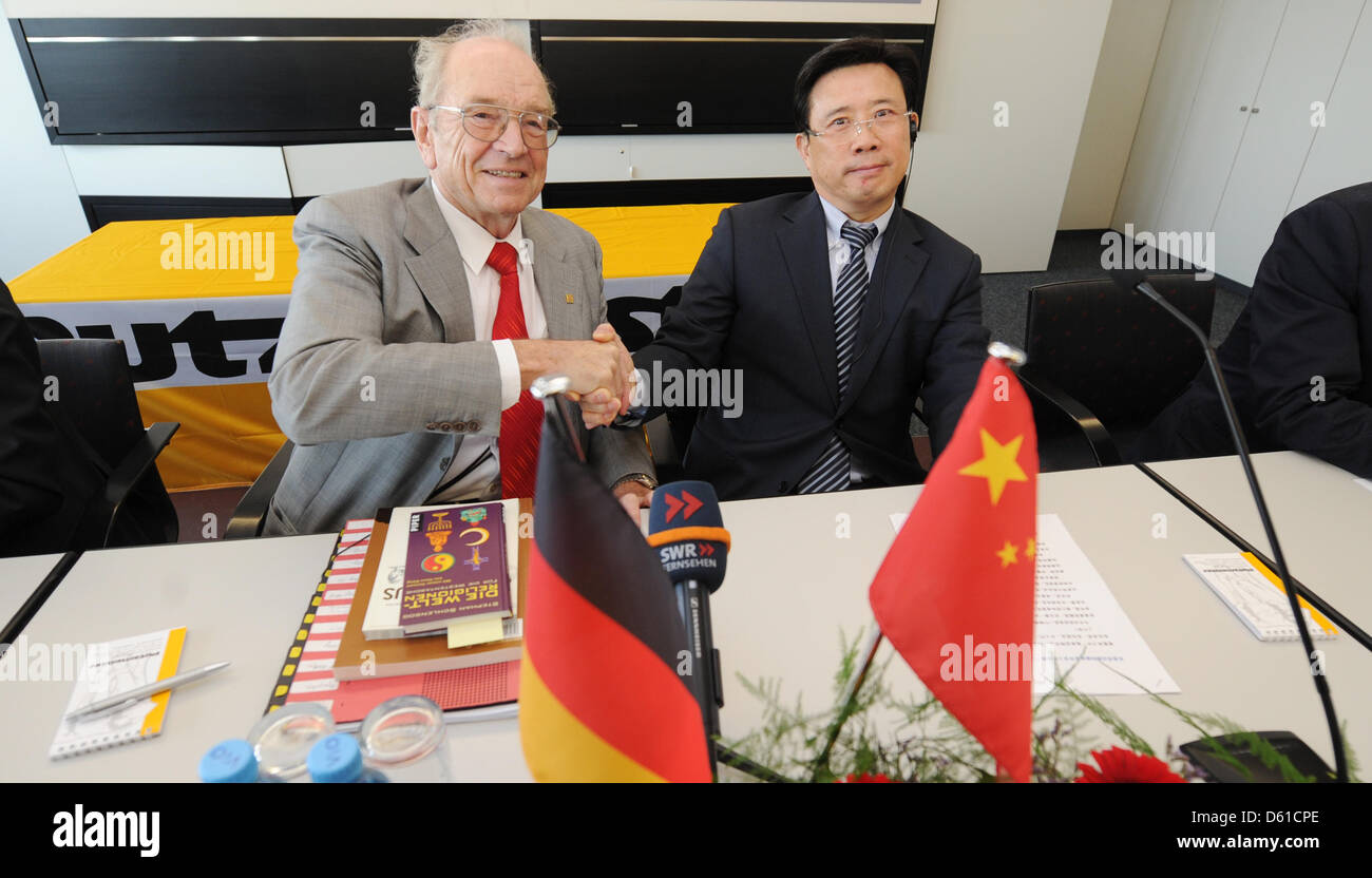 Founder of the concrete pump company Putzmeister, Karl Schlecht (L), and SANY Group chairman, Wengen Liang, sit on a table during a press conference in Aichtal, Germany, 17 April 2012. The Chinese company SANY will take over Putzmeister. Photo: FRANZISKA KRAUFMANN Stock Photo