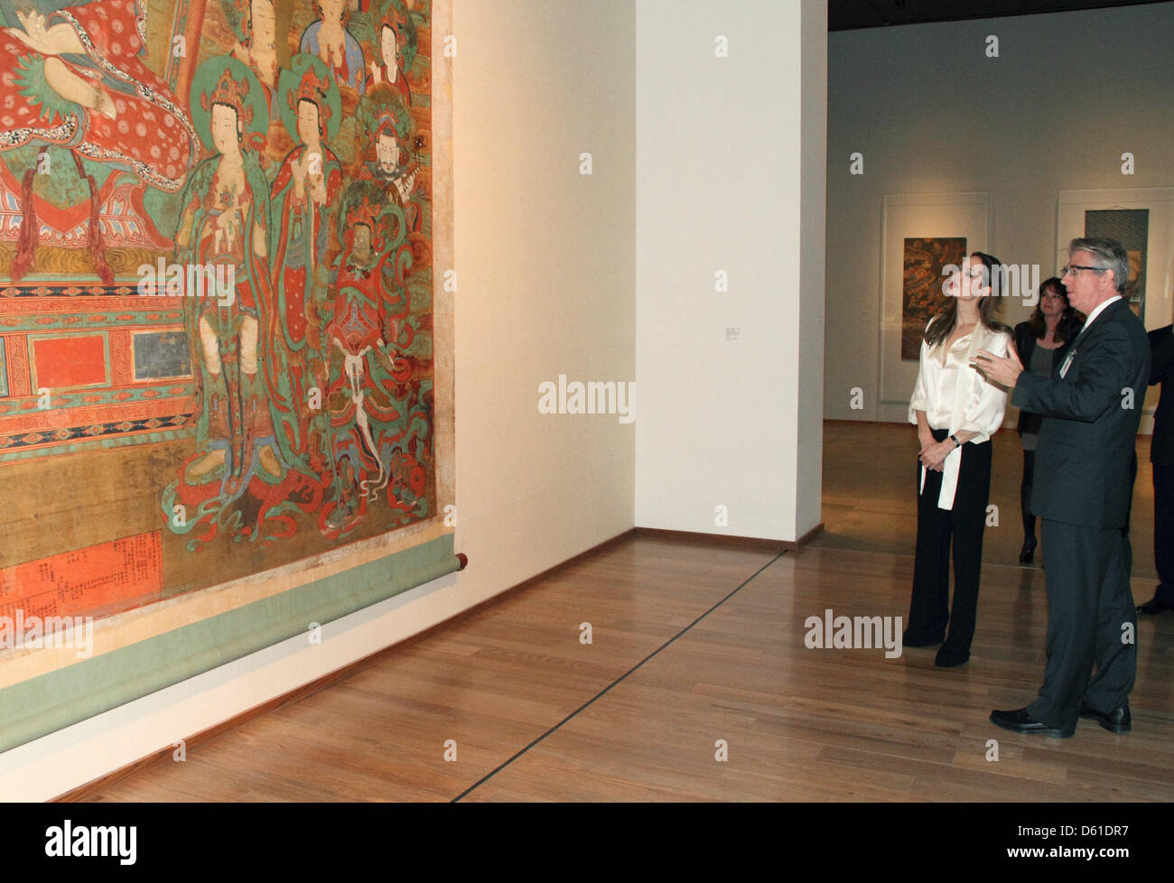 (HANDOUT) A handout dated 11 April 2012 shows American actors Angelina Jolie and Stephen Little, curator and director of Chinese and Korean art, looking at a piece from the collection of 'Chinese Art' at the Los Angeles County Museum of Art (LACMA) with their son Pax in Los Angeles, USA, 11 April 2012. Jolie is wearing the new engagement ring on her left ring finger which was made  Stock Photo