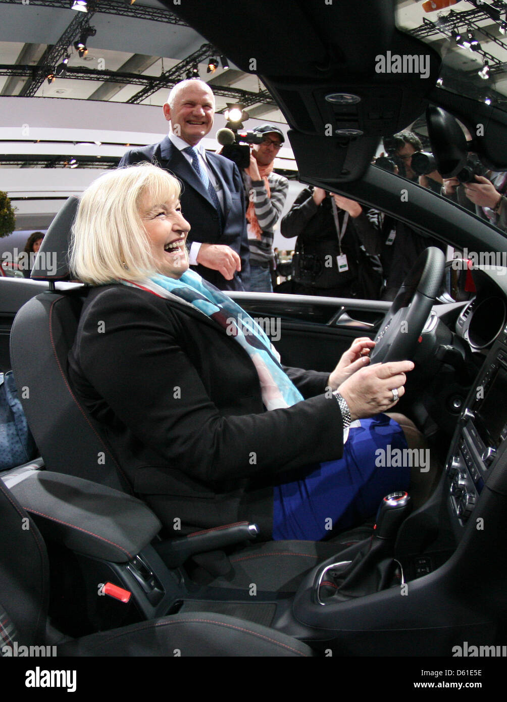 Chairman of Volkswagen Supervisory Board Ferdinand Piech stands next to his wife Ursula sitting in a VW Golf convertible car prior to the general meeting of car manufacturer  Volkswagen in Hamburg, Germany, 19 April 2012. Ursula Piech will be elected to the supervisory board during the meeting. Photo: CHRISTIAN CHARISIUS Stock Photo