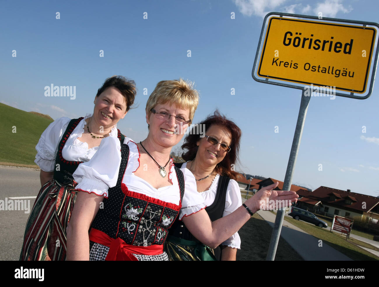 First mayor of Goerisried Thea Barnsteiner (C), second mayor Petra Muder (R) and third mayor Karin Knuesli (R) stand in front of the town limit sign in Goerisried, Germany, 23 March 2012. There are three mayors in the village of 1,300 resident in the Allgaeu. Photo: Karl-Josef Hildenbrand Stock Photo