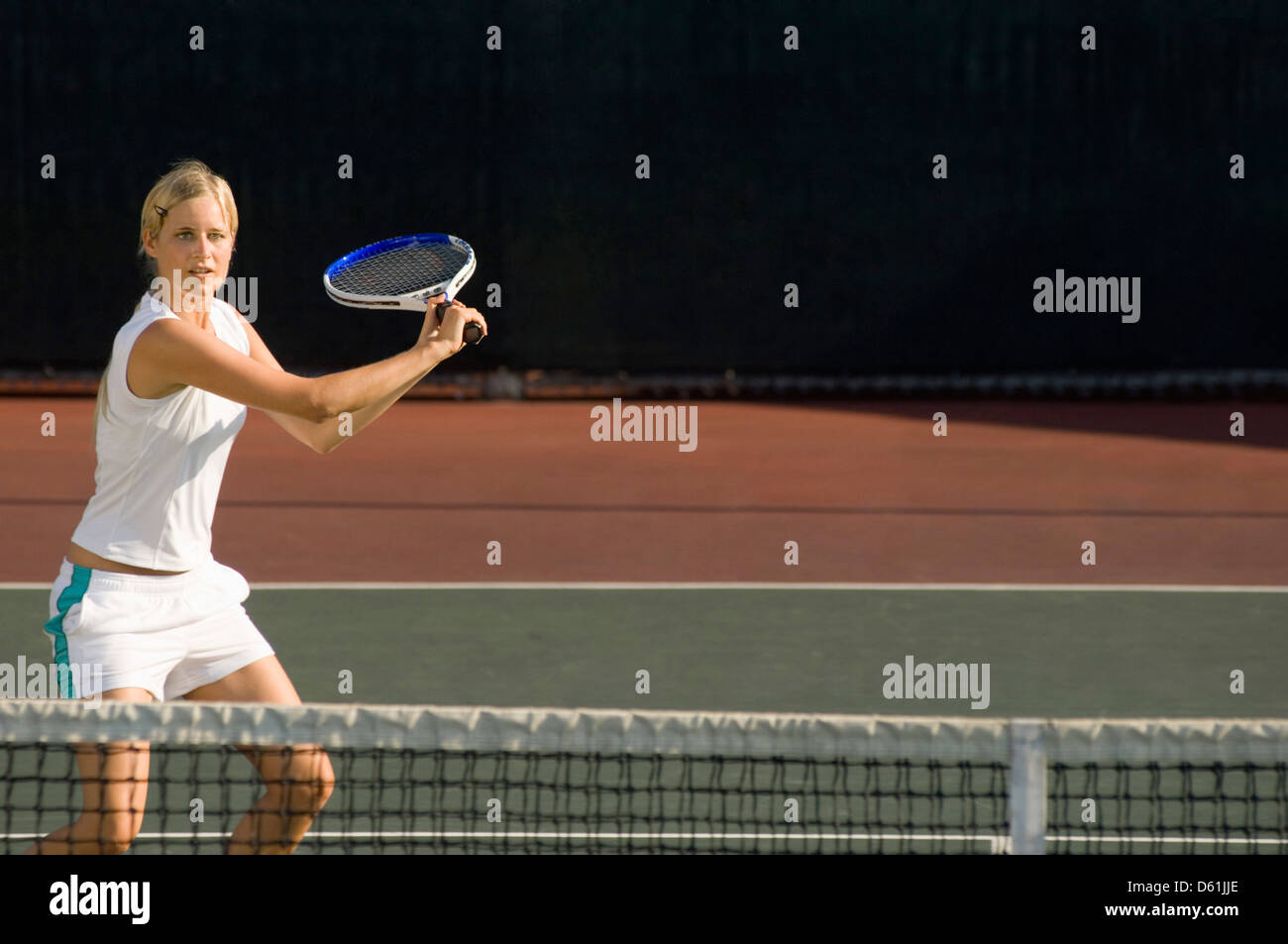 Young female tennis player swinging racket t court Stock Photo - Alamy