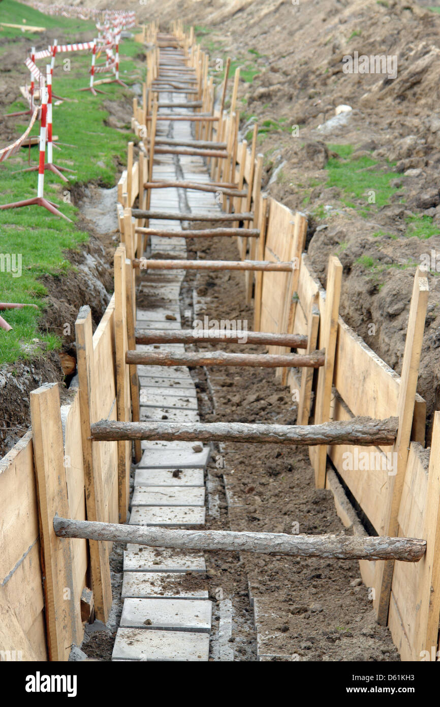 Long earth excavation protected on two sides by wooden shuttering Stock Photo