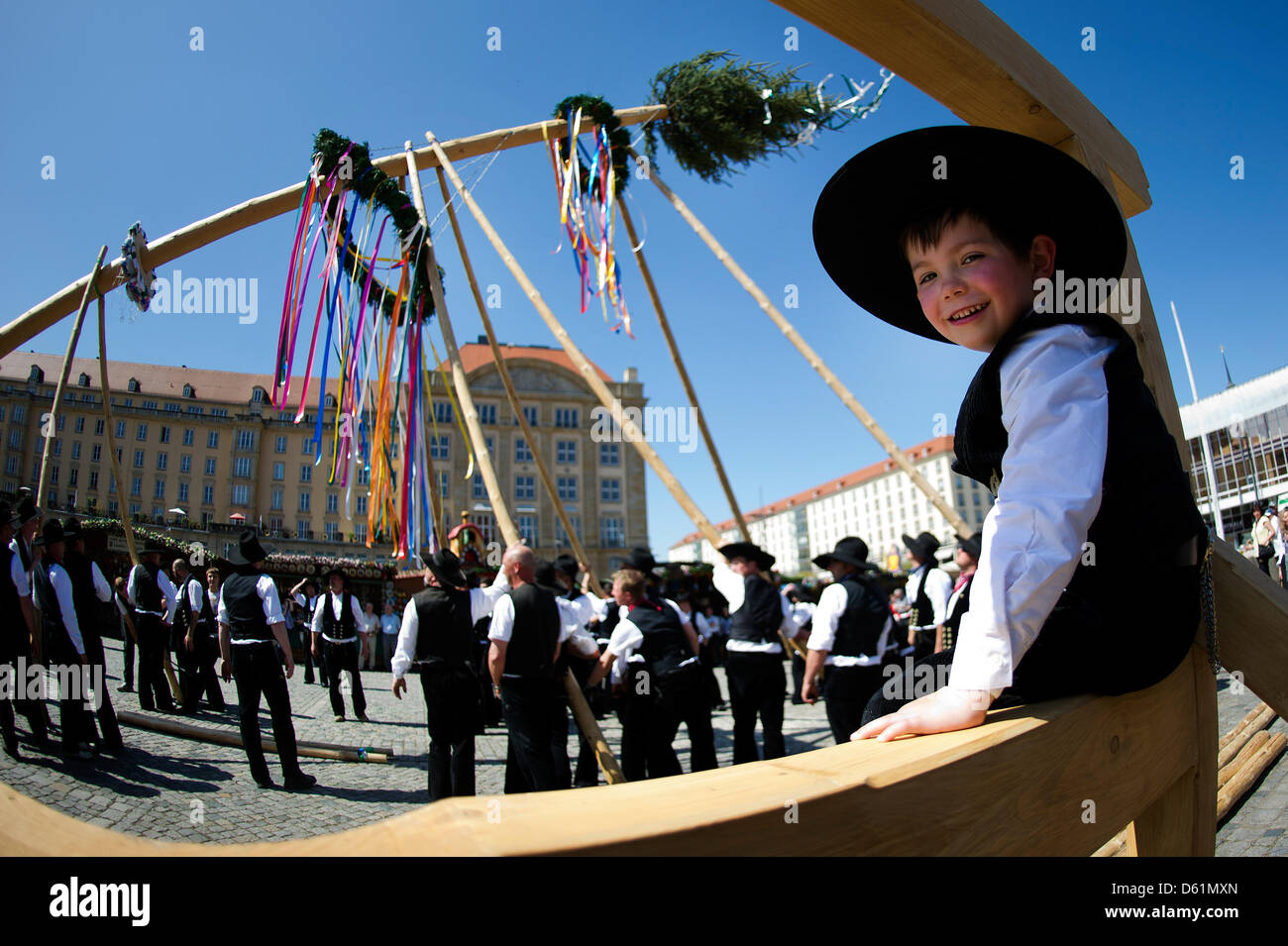 Young 'carpenter' Richard looks at his father during the traditional erecting of the maypole at the spring market (Altmarkt) in Dresden, Germany, 27 April 2012. The maypole is around 20 meters high and comes from Langebrueck in Dresdner Heide. Photo: Arno Burgi Stock Photo