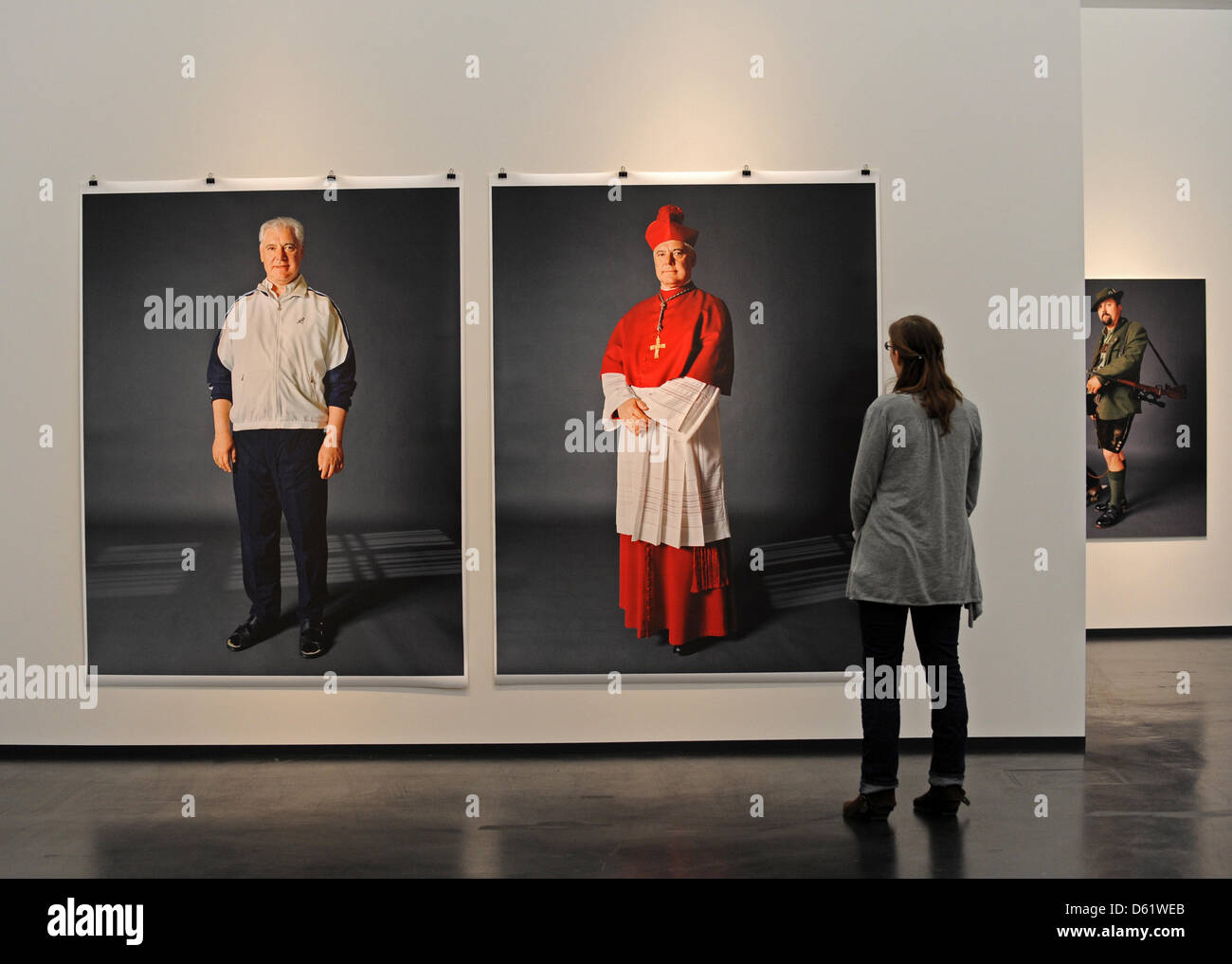 A woman views photos of Bishop Gerhard Ludwig Mueller during the new exhibition 'Kleider machen Leute' ('Clothes make the man') of photographer Herlinde Koelbl in Dresden, Germany, 03 May 2012. Koelbl's exhibition at the German Hygiene Museum Dresden showing people in casual and professional clothing is open until 29 July 2012.  Photo: MATTHIAS HIEKEL Stock Photo