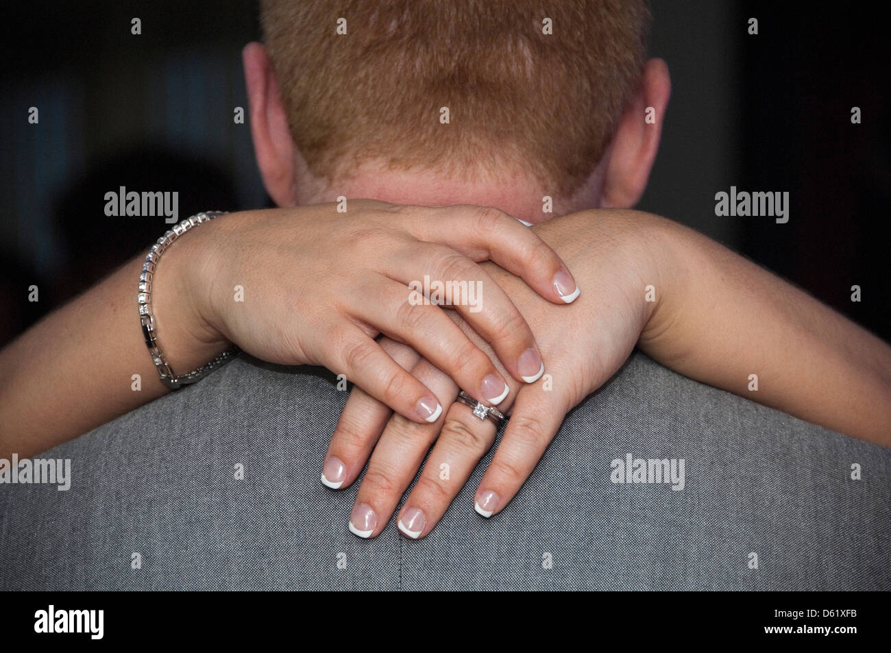 Horizontal close up of a woman's hands around a man's neck during a dance. Stock Photo