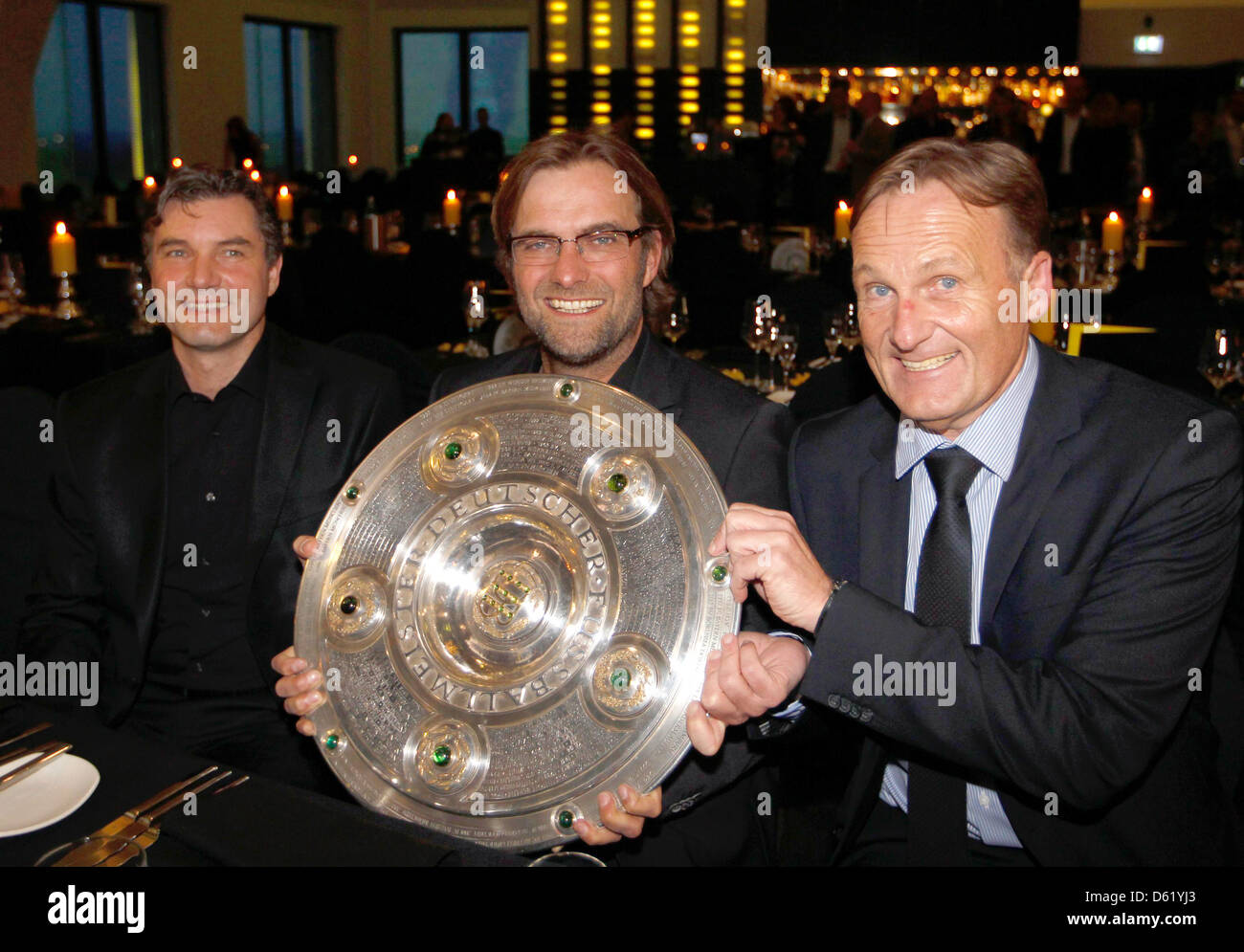Borussia Dortmund's manager Michael Zorc (L-R), head coach Juergen Klopp and club CEO Hans-Joachim Watzke pose with the German soccer championship trophy during a dinner after winning the German Bundesliga soccer championship in Dortmund, May 5, 2012. Photo: Ina Fassbender Reuters Pool;dpa Stock Photo