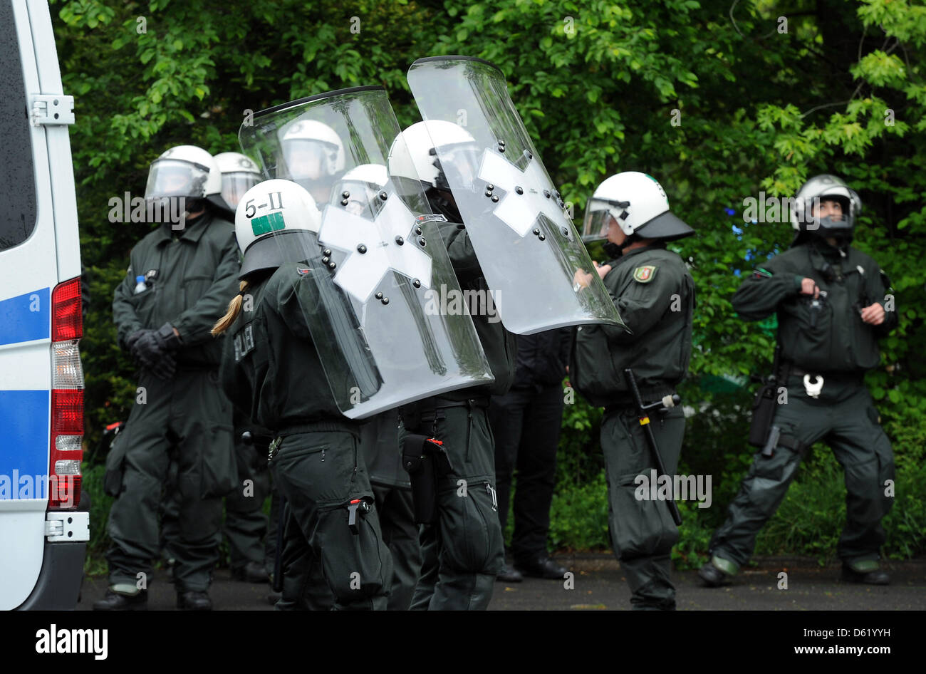 Police officers protect themselves against stone throwers at election campaign rally of the Pro NRW party in front of the King Fahd Academy in Bonn, Germany, 05 May 2012. Repeatedly violence broke out when members of the right-wing party provoked Salafis. 29 police officers were injured during the riots, two suffered knife thrusts. None of them was in mortal danger. Photo: HENNING  Stock Photo