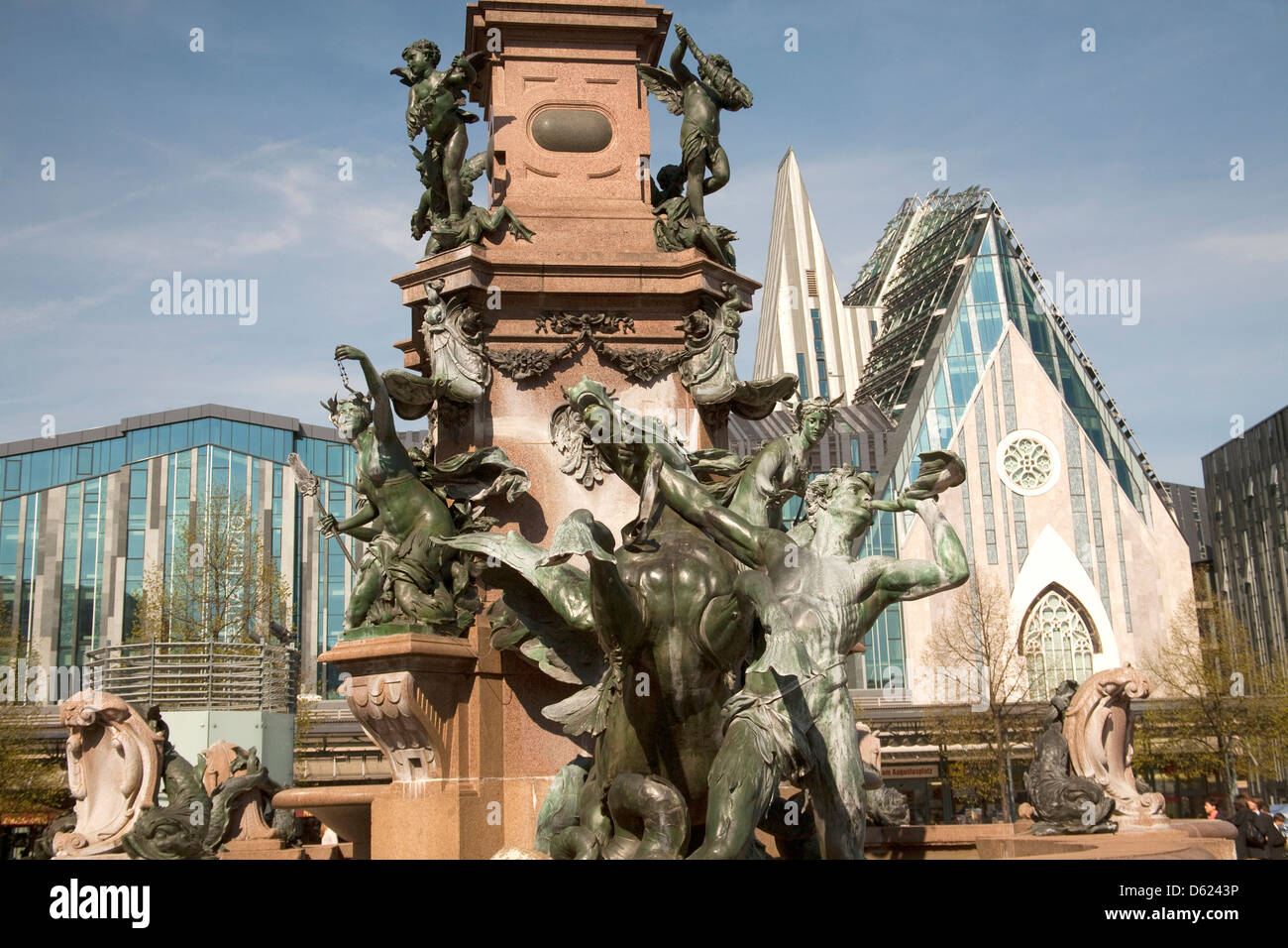 Detail of monument in center of Augustus Plaza, center of Leipzig. Glass facade of new Leipzig University in background. Stock Photo