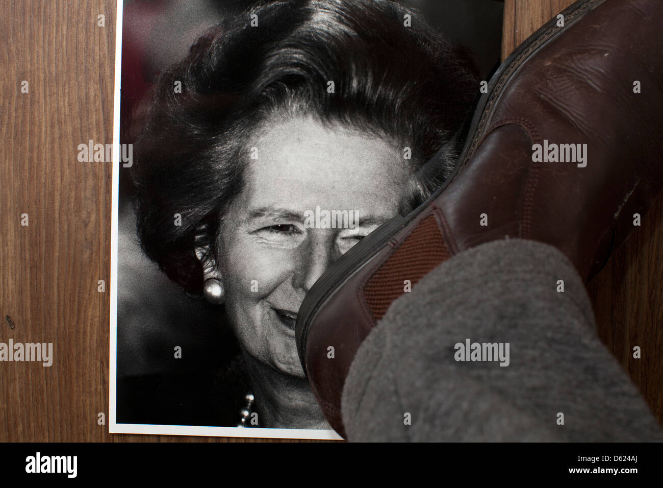 Tramp the dirt down. A picture of former British Prime Minister Margaret Thatcher is  stamped on Stock Photo