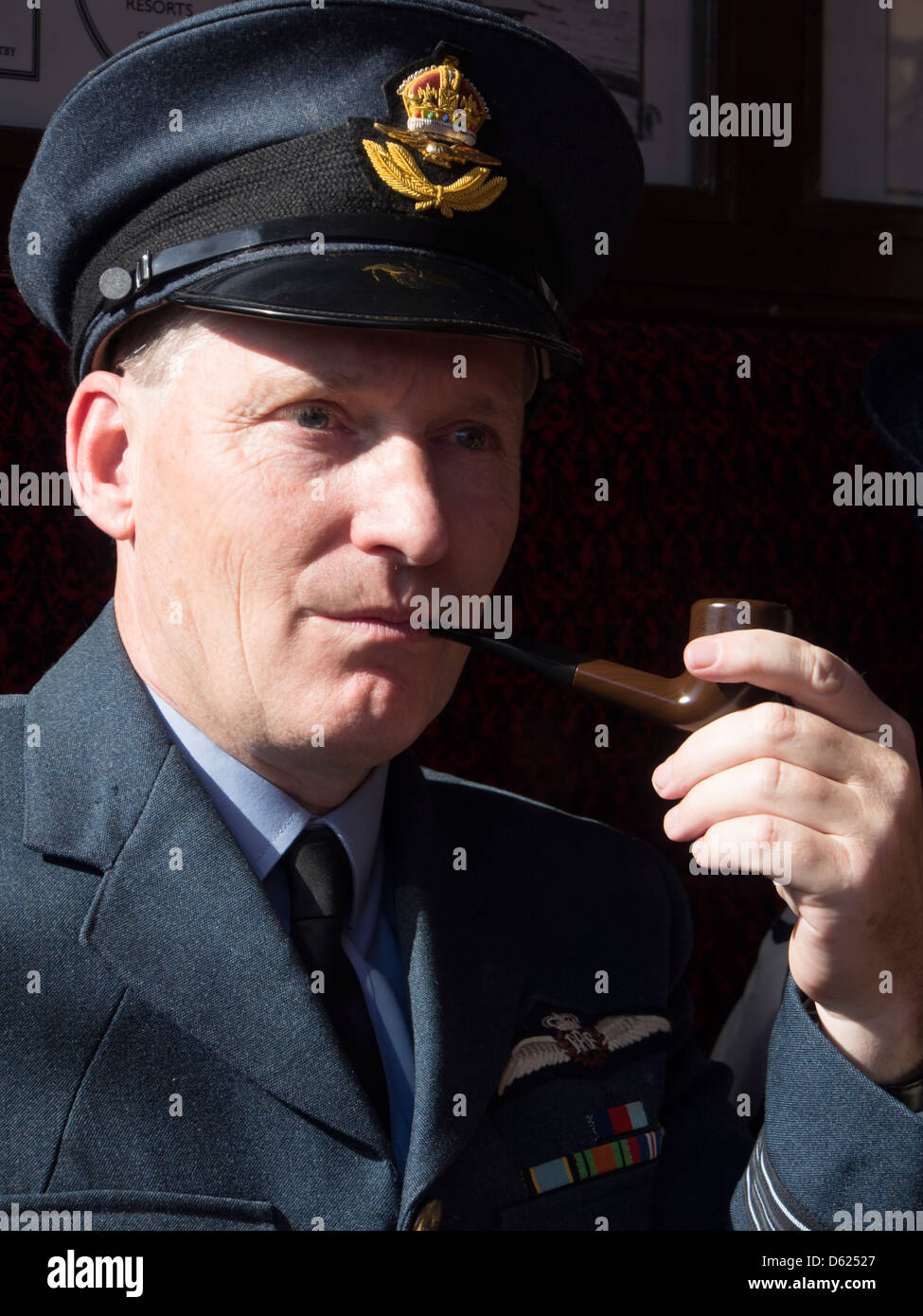Man smoking pipe  dressed in RAF uniform  for 1940s weekend on Sheringham station in Norfolk East Anglia England Stock Photo