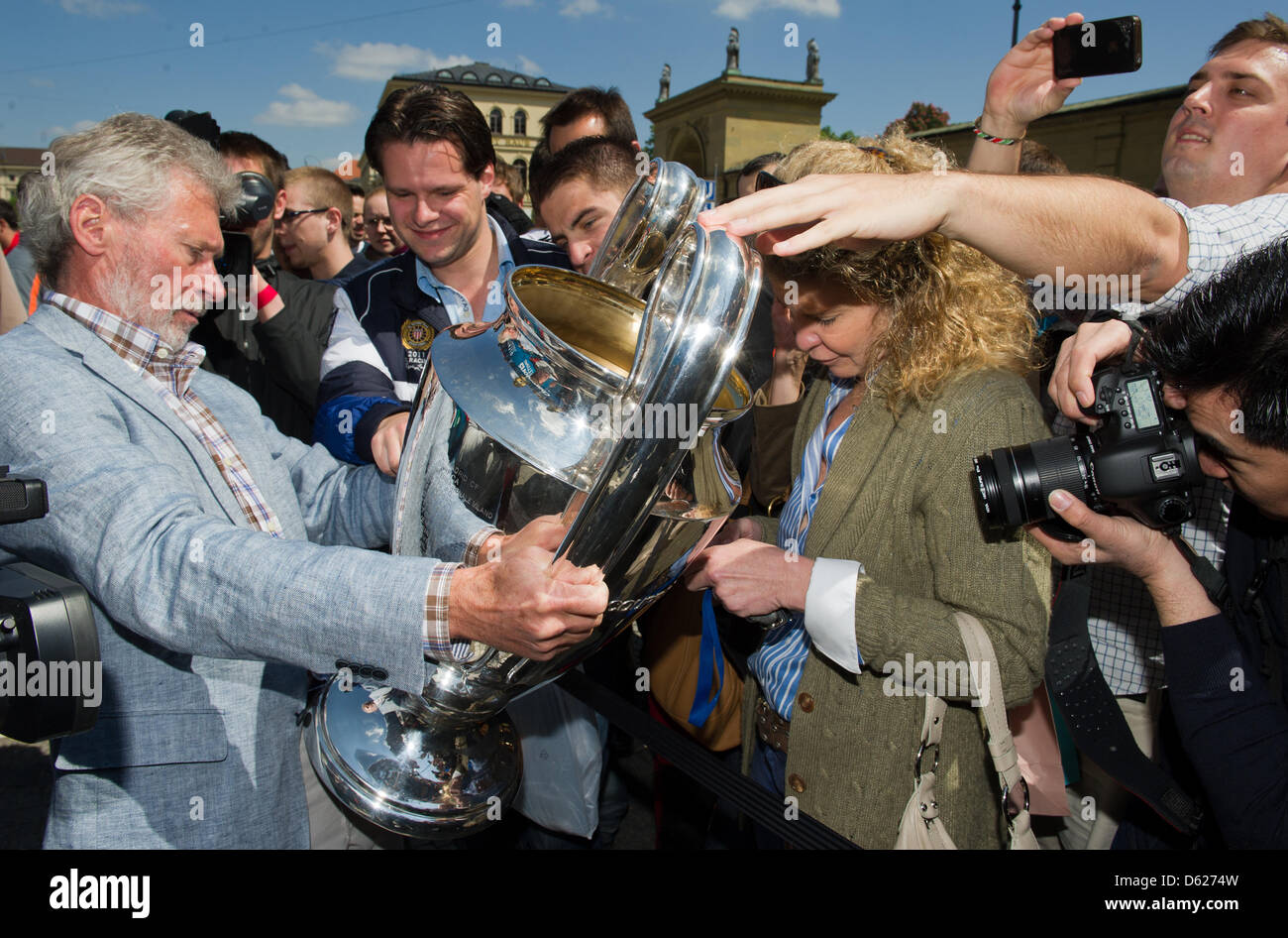 Former Bayern Munich soccer players Paul Breitner (L) presents the UEFA Champions League Cup during a Champions League Cup bus tour in Munich, Germany, 14 May 2012. The Champions League final match between FC Bayern Munich and Chelsea FC will take place on 19 May 2012. Photo: PETER KNEFFEL Stock Photo