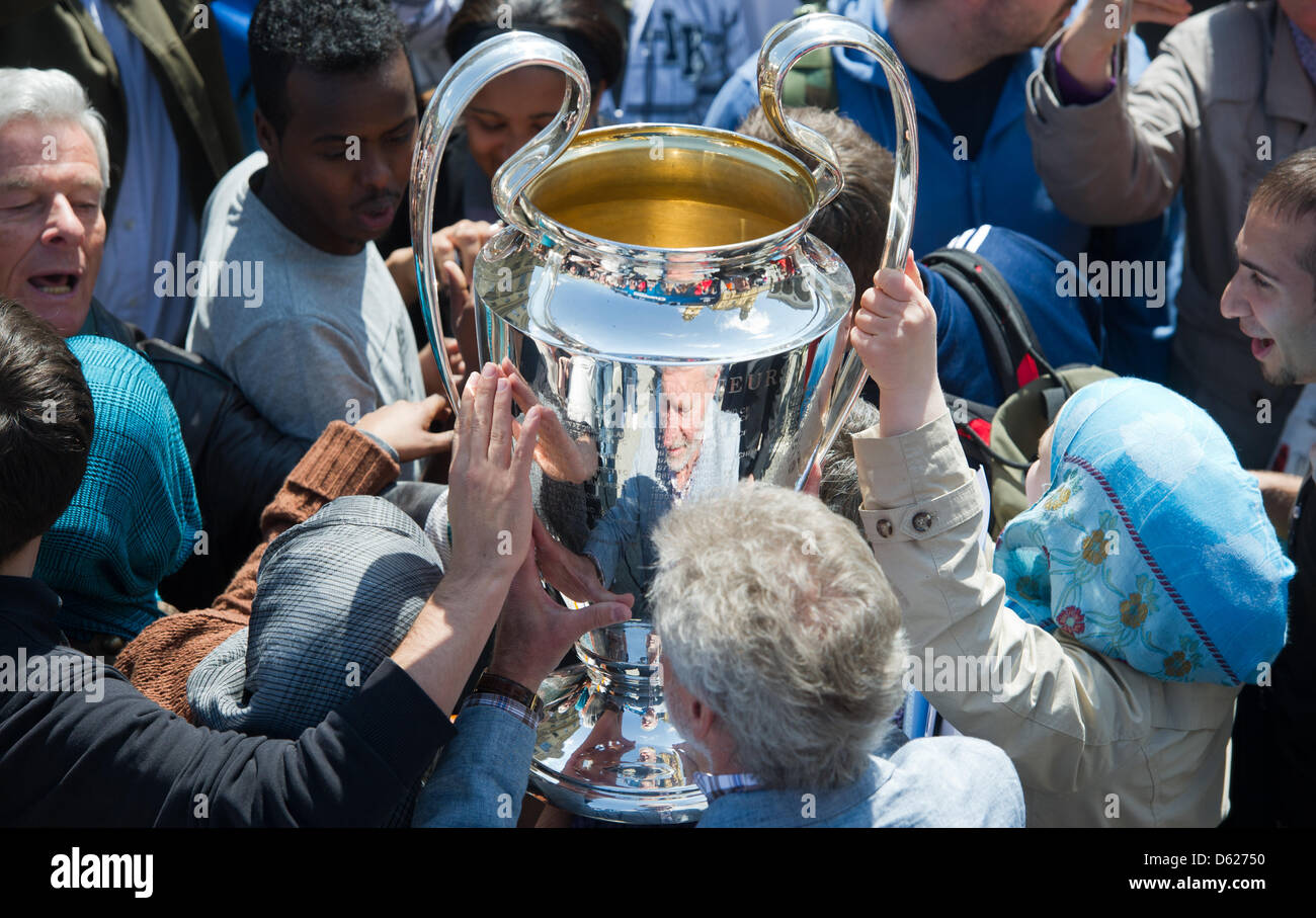 Former Bayern Munich soccer players Paul Breitner (bottom, blue jacket) presents the UEFA Champions League Cup during a Champions League Cup bus tour in Munich, Germany, 14 May 2012. The Champions League final match between FC Bayern Munich and Chelsea FC will take place on 19 May 2012. Photo: PETER KNEFFEL Stock Photo