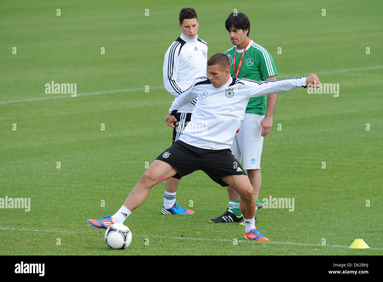 Germany's Lukas Podolski (front) practices under the eyes of head coach Joachim Loew and teammate Julian Draxler on a pitch near Callian, France, 18 May 2012. The German national team is preparing for the Euro 2012 in southern France until 20 May. Photo: ANDREAS GEBERT Stock Photo