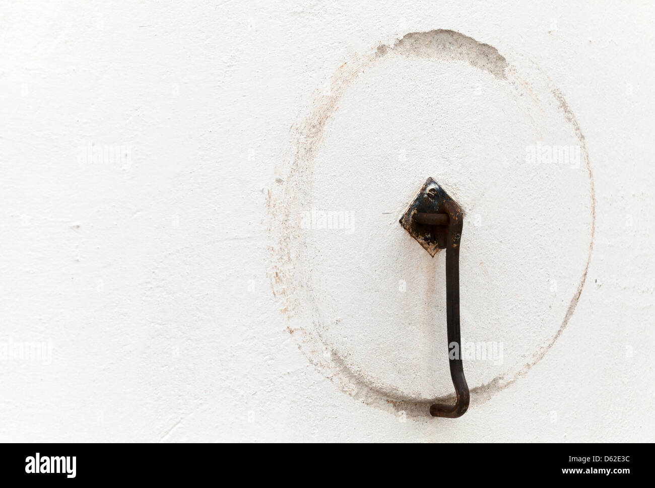 Ancient door hook with round trace on white wall. Old part of Tallinn, Estonia Stock Photo