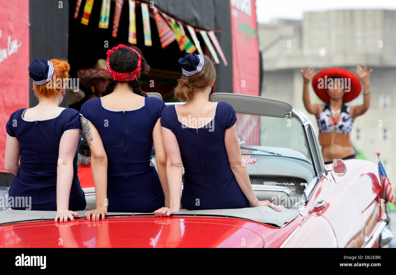 An American convertible with three burlesque dancers drives to the stage during the 'Street Mag Show' at the US Car and Motorbike Show in Hamburg, Germany, 19 May 2012. The show presents American cars from the 30s to the 80s. Photo: Daniel Bockwoldt Stock Photo