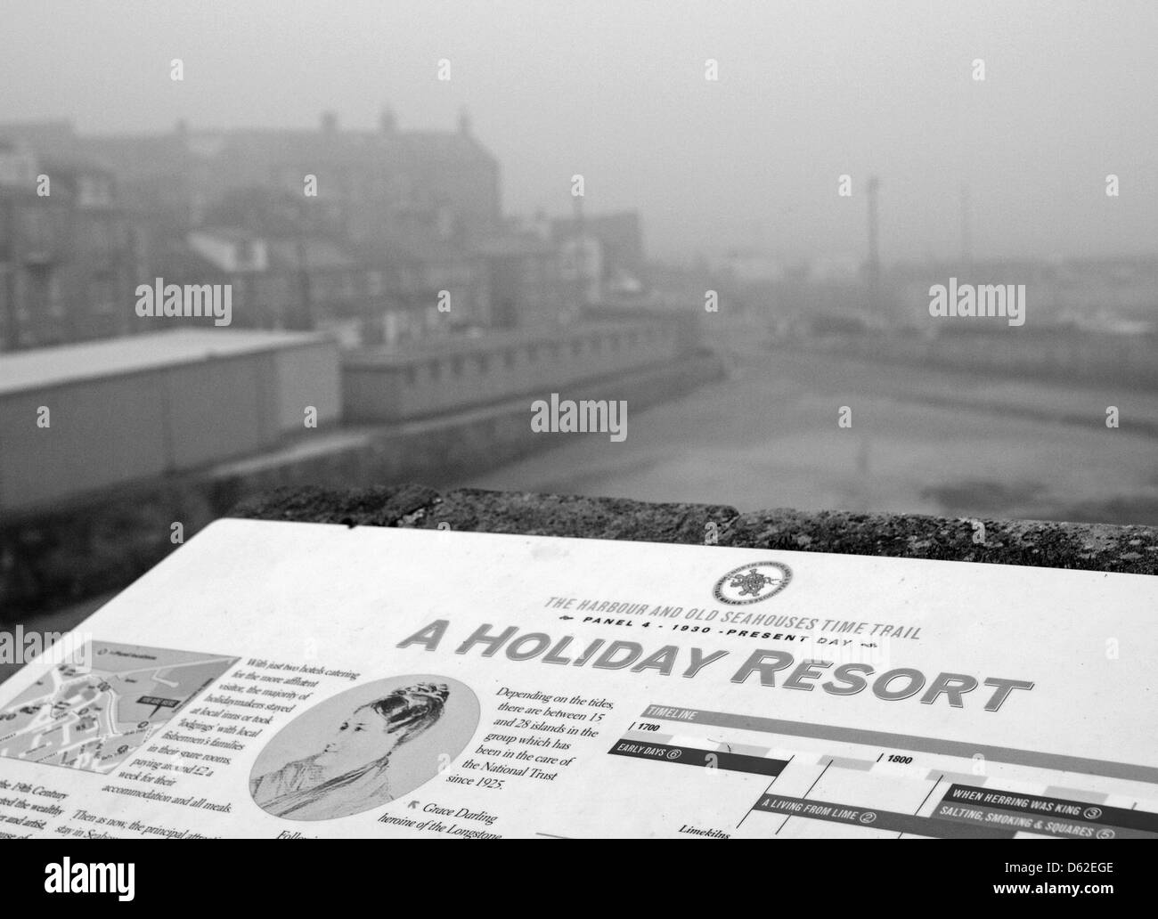 Close up of an information panel advertising a 'Holiday Resort' with the background showing a grey overcast day. Stock Photo