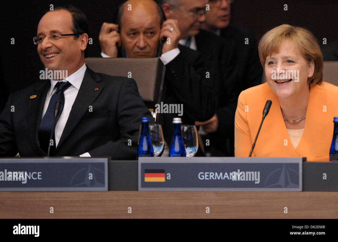Frankreichs Präsident Francois Hollande (l) und Bundeskanzlerin Angela Merkel (CDU) lächeln am Sonntag (20.05.12) in Chicago (USA) bei der ersten Arbeitssitzung des NATO-Gipfels. Foto: Michael Gottschalk Stock Photo