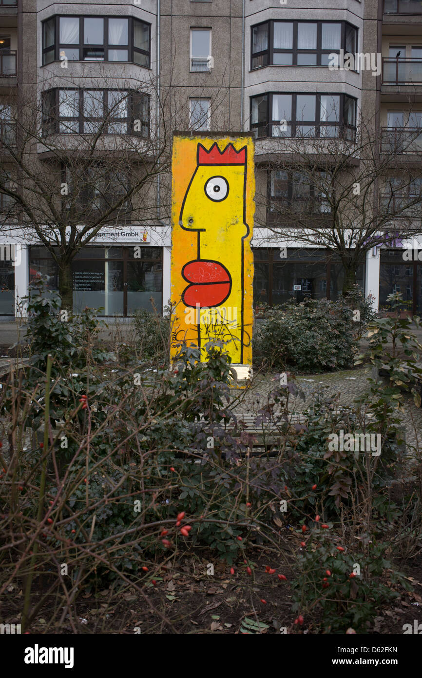 A painted section of the old Berlin wall standing in a pedestrian precinct, near Checkpoint Charlie in central Berlin. The Berlin Wall was a barrier constructed by the Communist German Democratic Republic (GDR, East Germany) starting on 13 August 1961, that completely cut off (by land) West Berlin from surrounding East Germany and from East Berlin. Stock Photo