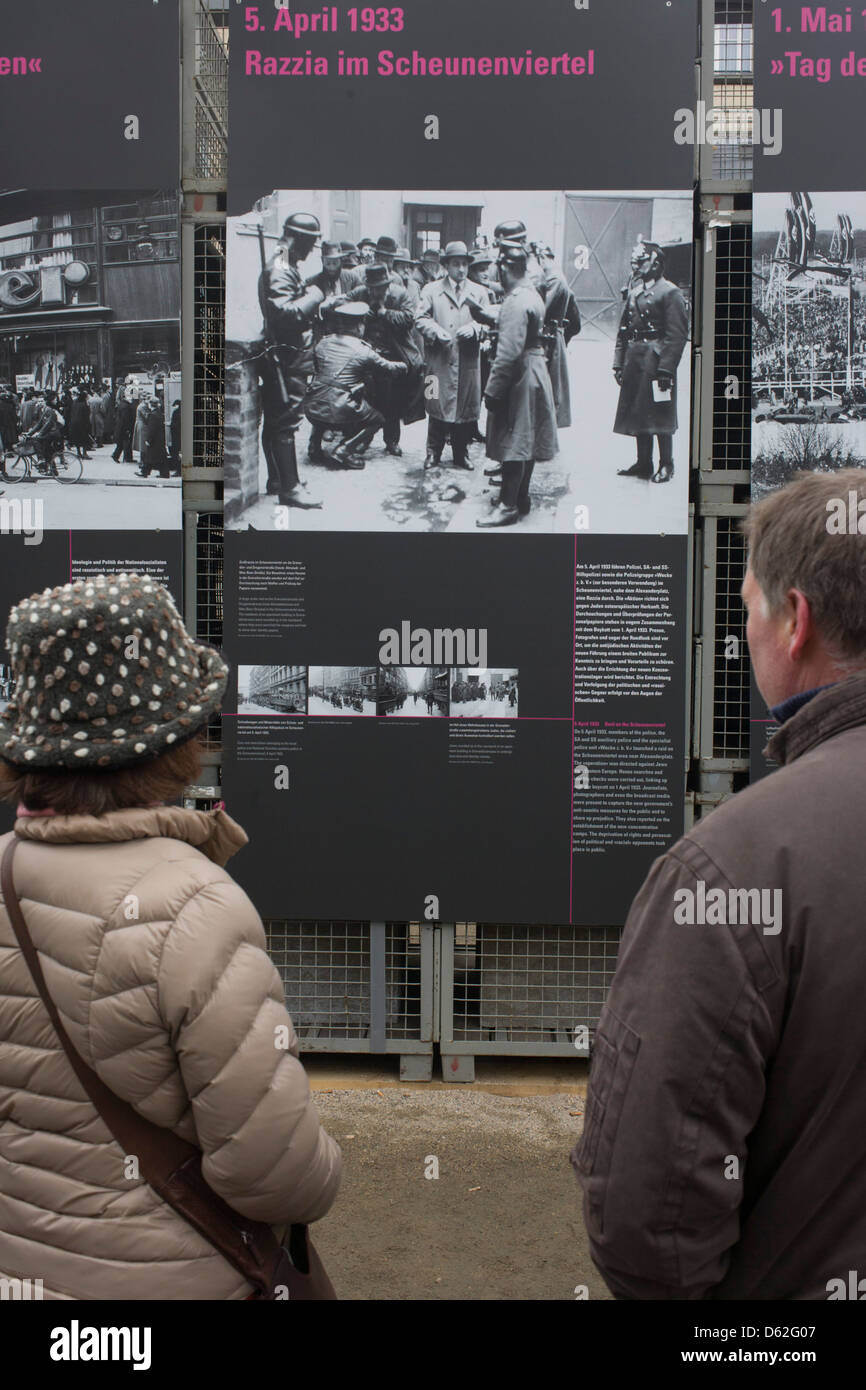 Tourists learn more about German history by reading outdoor exhibition panels telling the story of Nazi fascism during the 1930s and 40s, in Unter den Linden and opposite the Brandengurg Gate. Stock Photo