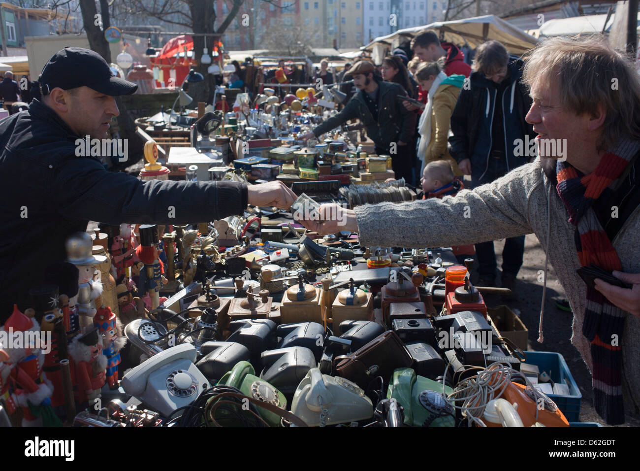 Euros changing hands for bric-a-brac and old possessions, sold at a giant market in Mauerpark - an open space on the site of the old Berlin wall, the former border between Communist East and West Berlin during the Cold War. Stock Photo