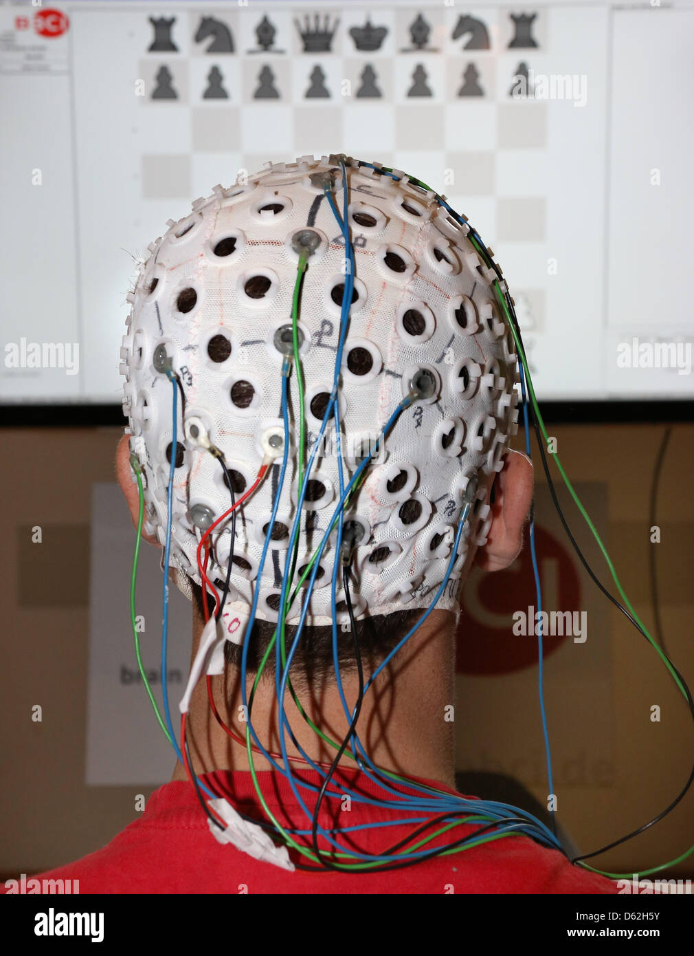 Sven Daehne plays chess with an EEG cap (Electroencephalogram) at the Technical University in Berlin, Germany, 22 May 2012. The EEG cap measures brain waves which are decoded by a computer. The demonstration took place for the upcoming long night of science. Photo: STEPHANIE PILICK Stock Photo