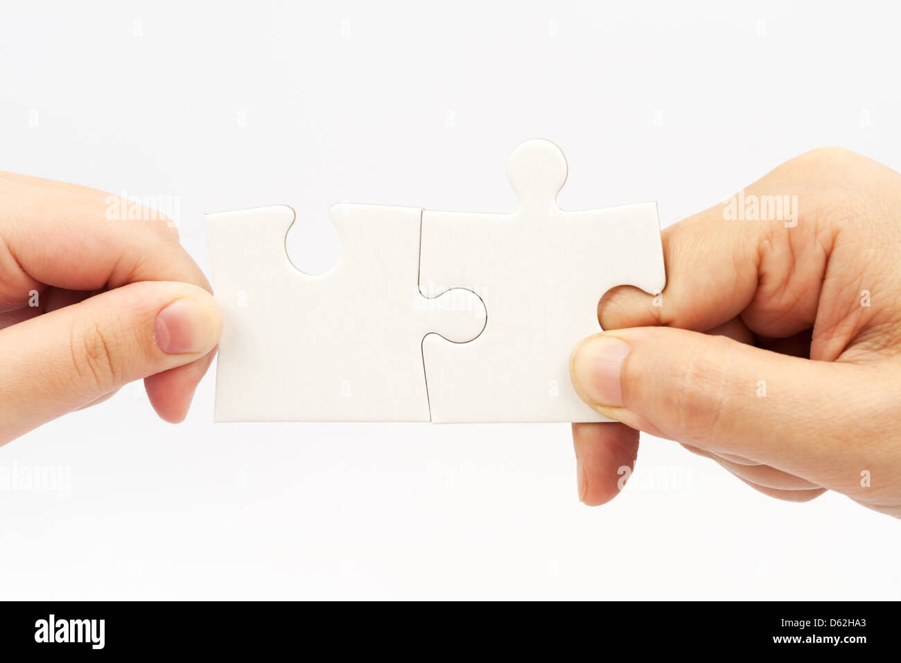 Two hands holding puzzle pieces and connecting them Stock Photo Alamy