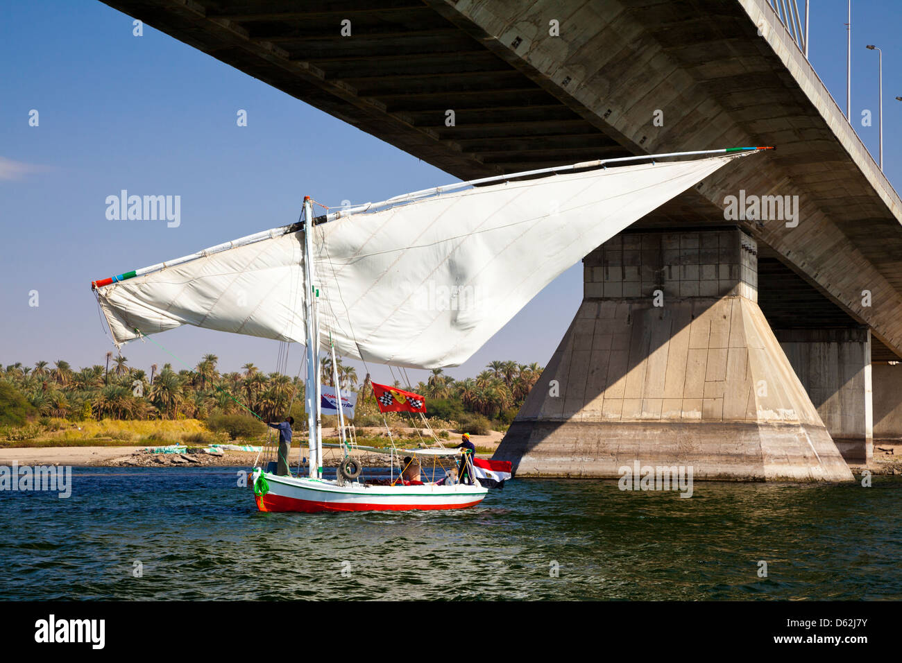 Traditional felucca sailboat tilting its sail as it moves underneath a