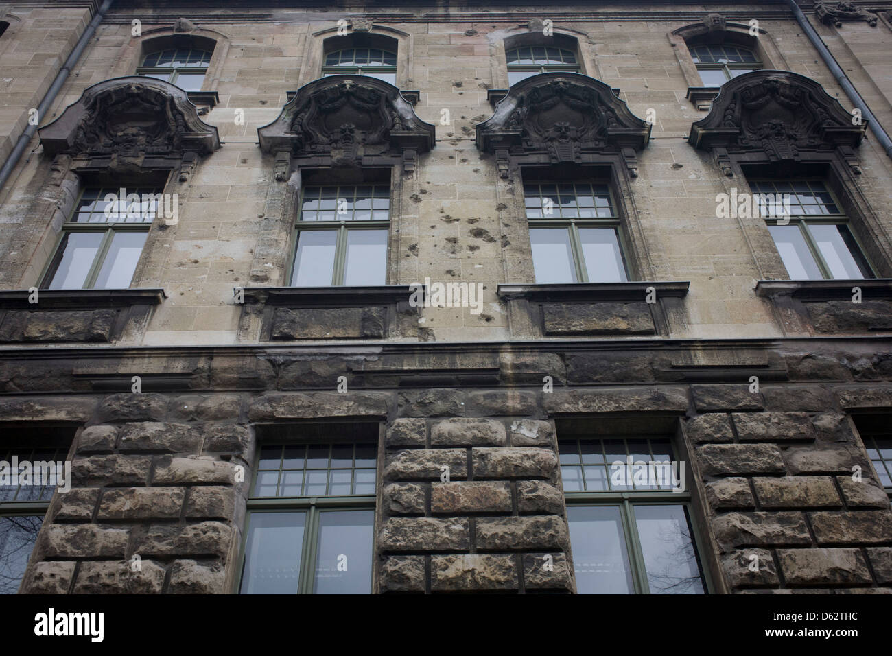 The blackened and ricochet-scarred stonework of an old building dating from before the second world war, marked during the battle for the city during the fall of the Third Reich, the end of Nazi fascism in the spring of 1945. Stock Photo