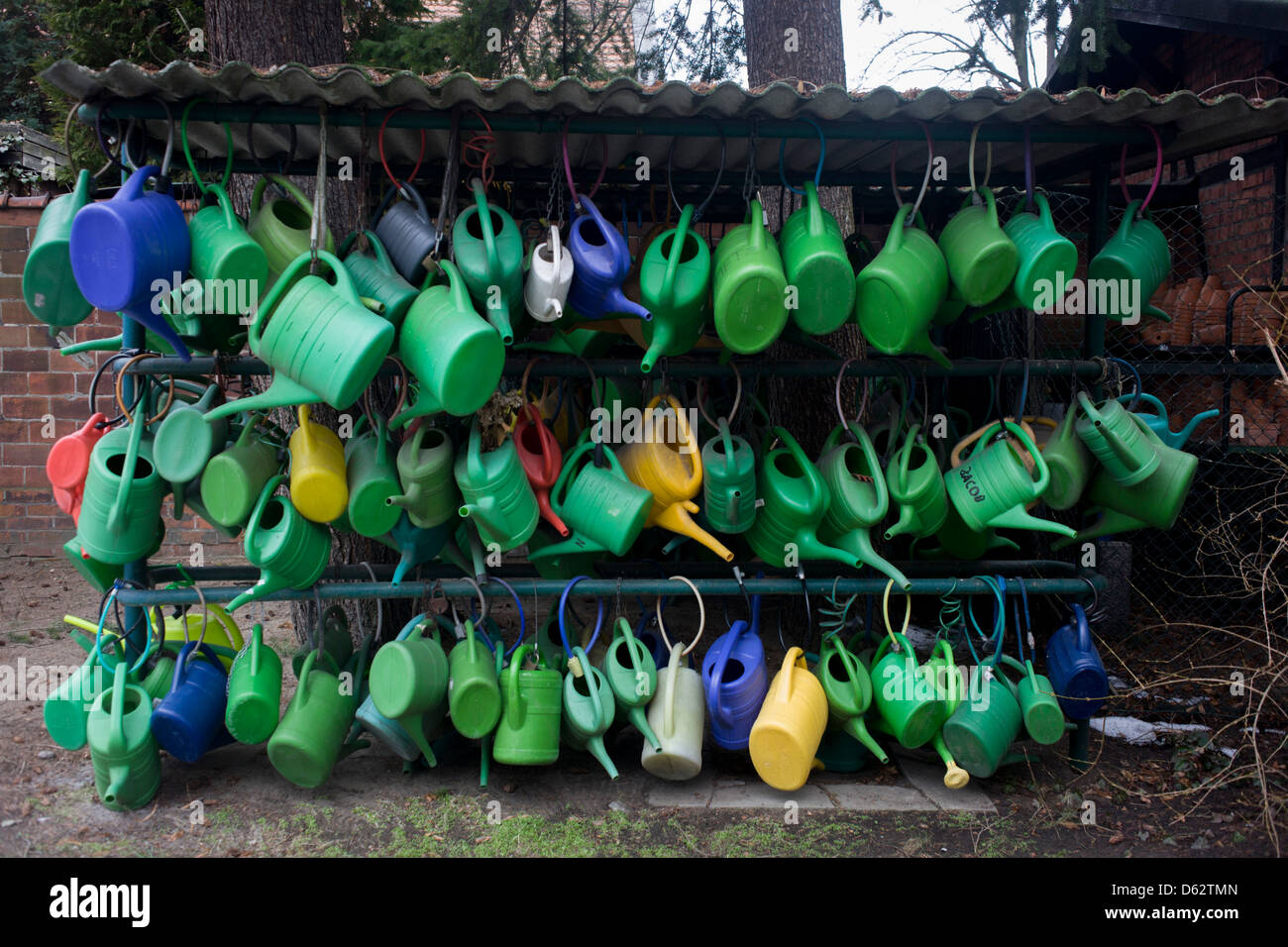 The watering cans of cemetery visitors which help water the graves of loved-ones are locked up on a rack in Domfriedhof in Wedding, a north-western district of Berlin. Stock Photo