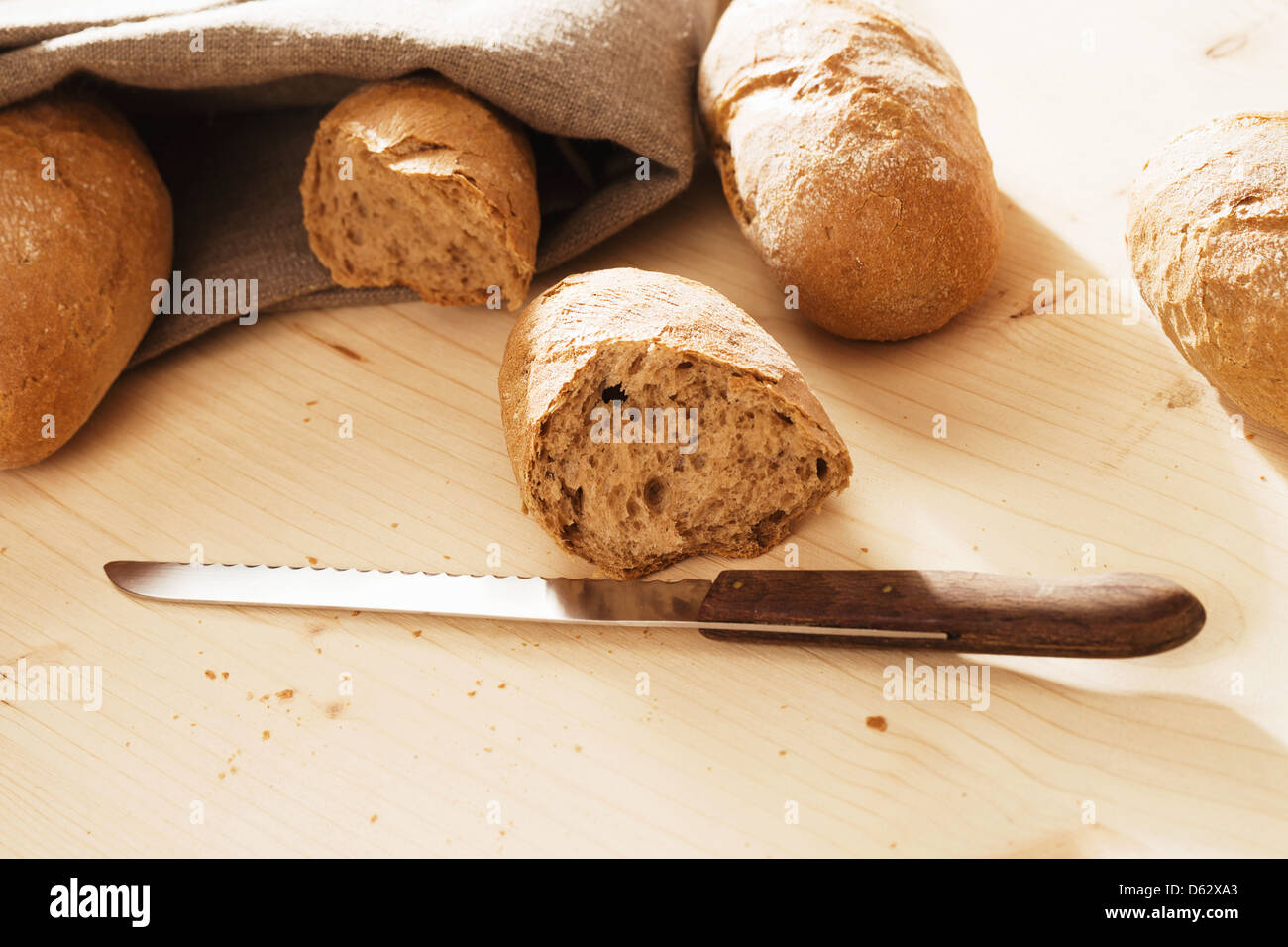broken rye bun with a knife in front of other rye buns Stock Photo - Alamy