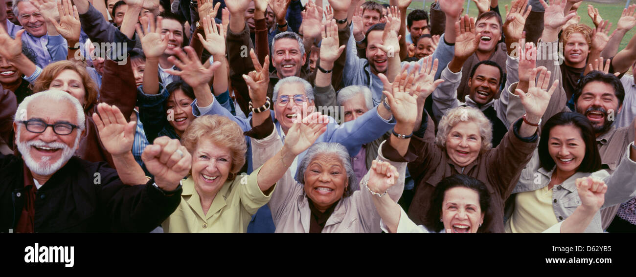 Large group of multi-ethnic people cheering with rms raised Stock Photo