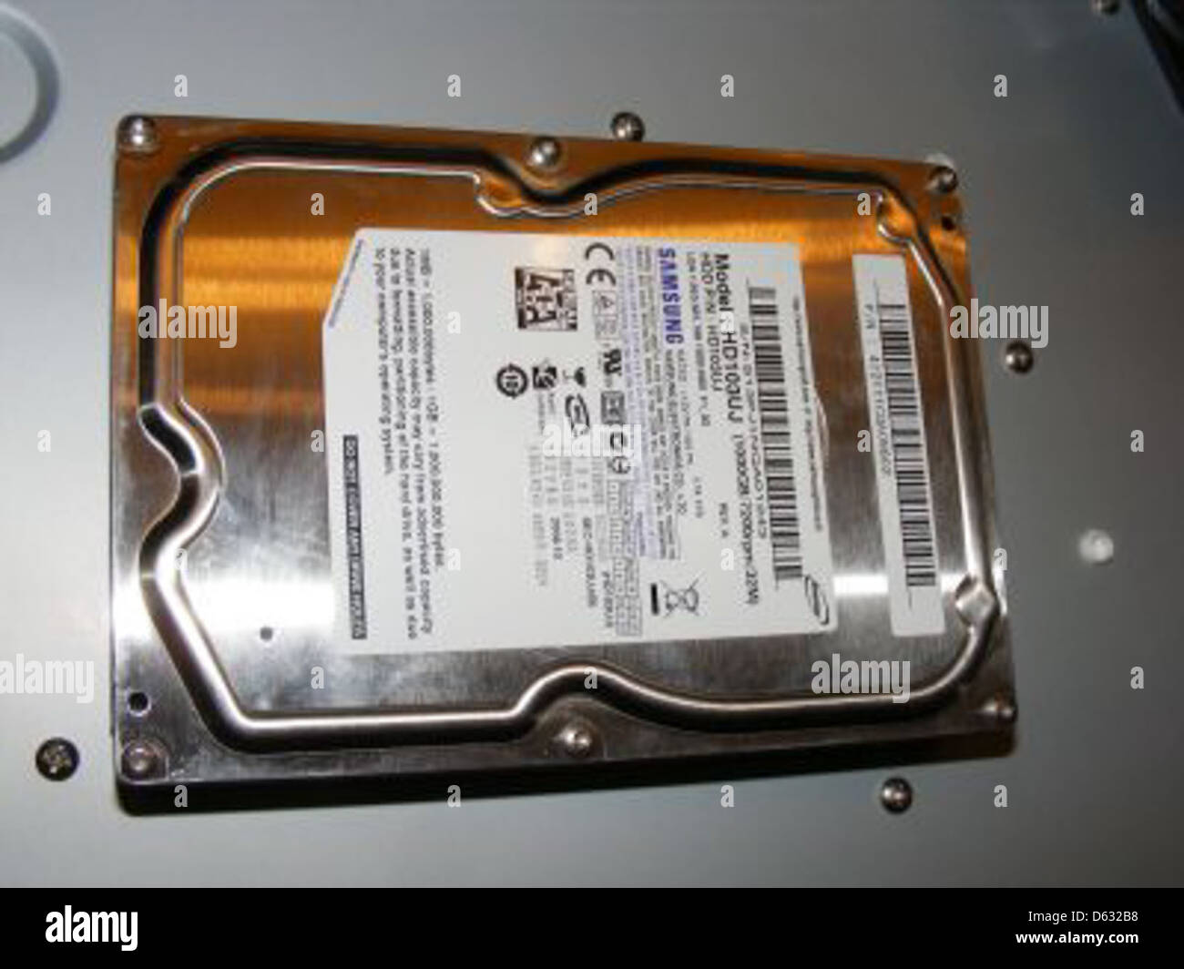 This image features a Samsung 1TB hard drive, model HD103UJ, showing ...
