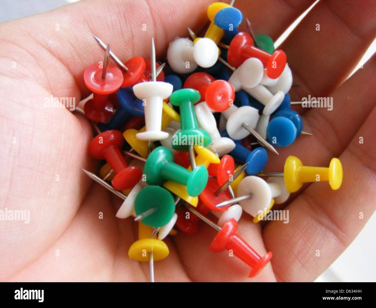 A collection of colored push pins arranged on a surface. These push ...
