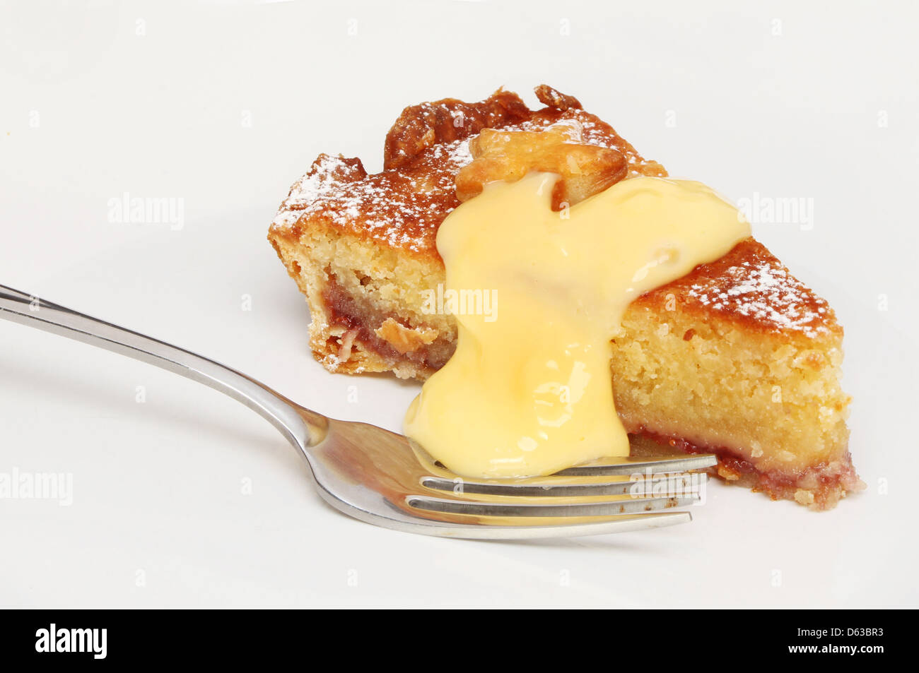 Closeup of a slice of Bakewell tart and custard with a fork Stock Photo