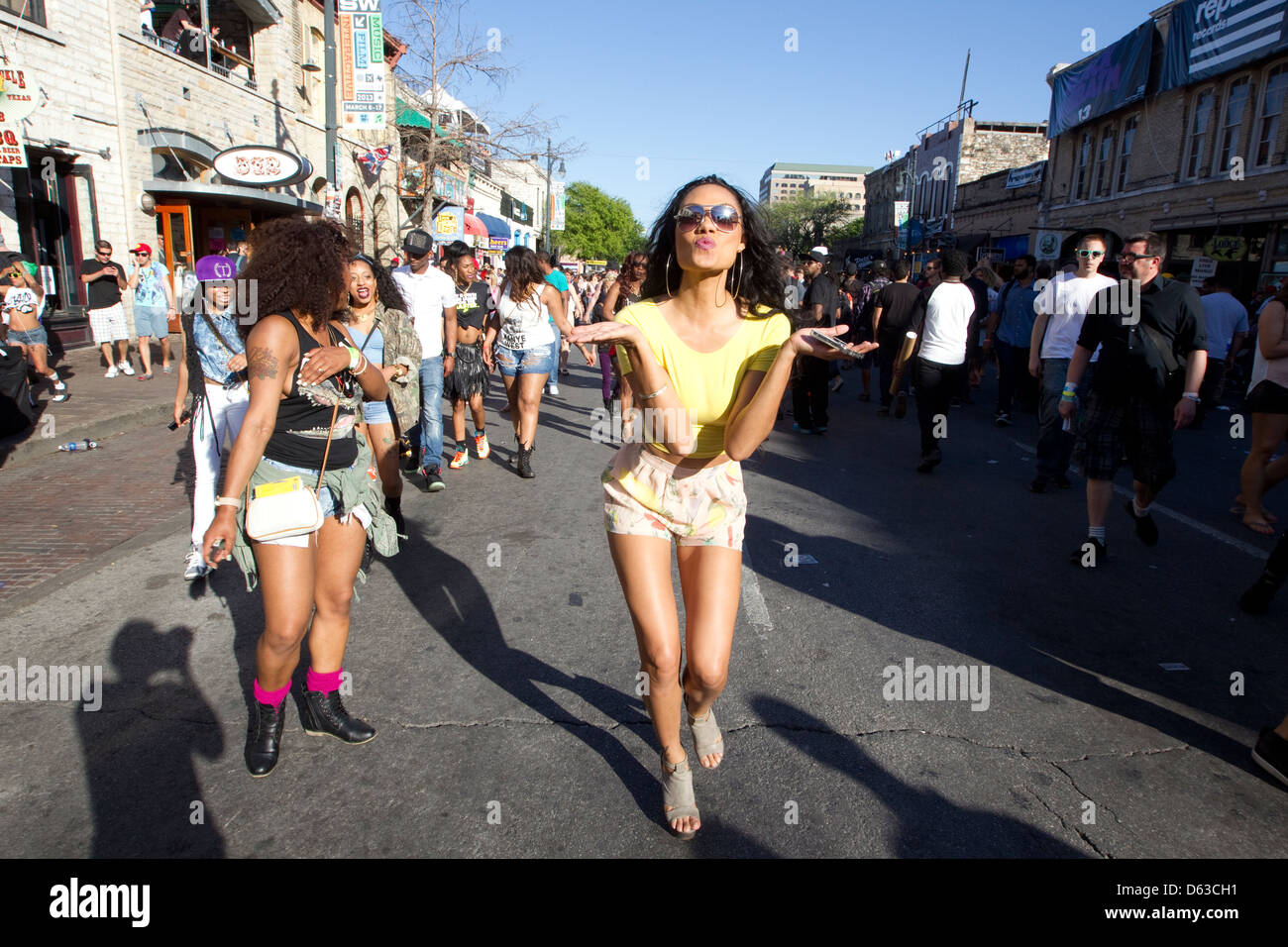 Female blows a kiss while she walks along a street during the South by Southwest music festival in Austin, Texas. Stock Photo