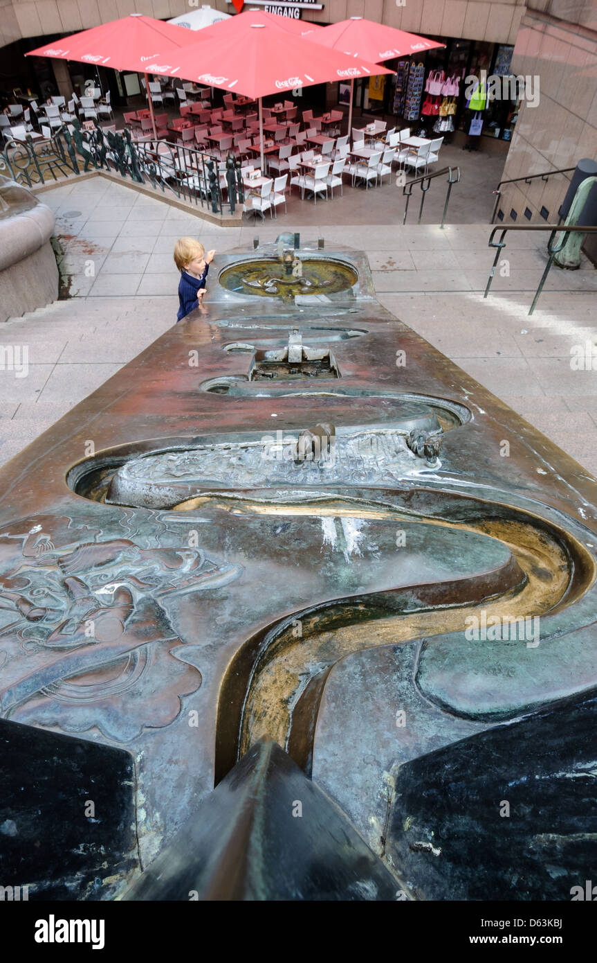 Child observing the fountain at Europa Center Berlin, Germany. Stock Photo